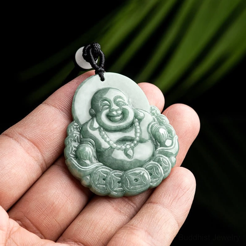 Laughing Buddha jade pendant held in hand showing compact size and smooth jade texture for daily wear