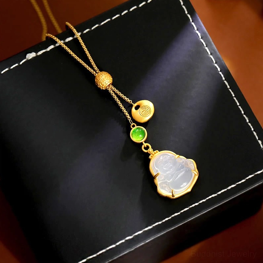 Handcrafted Buddhist necklace from above, displaying intricately carved gold beads and smooth white chalcedony Buddha charm on stitched leather pad