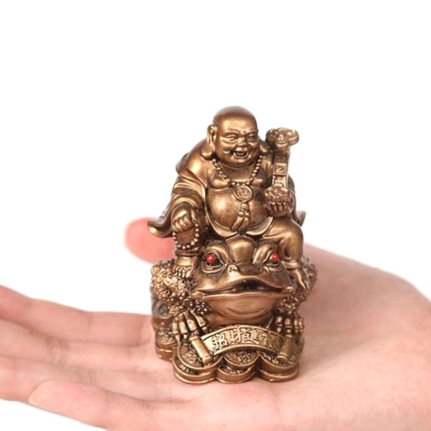 Hand holding laughing buddha money toad statue showing compact size and bronze finish with lucky coin charm