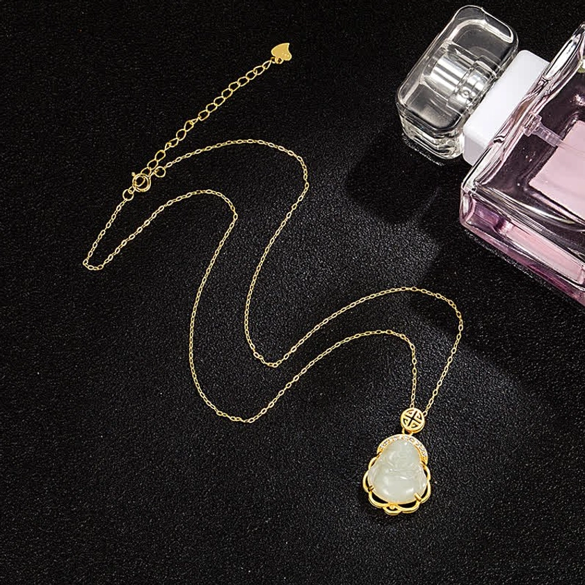 Loose Hetian white jade Laughing Buddha pendant necklace flat lay with sterling silver chain on dark studio surface, jewelry styling photograph