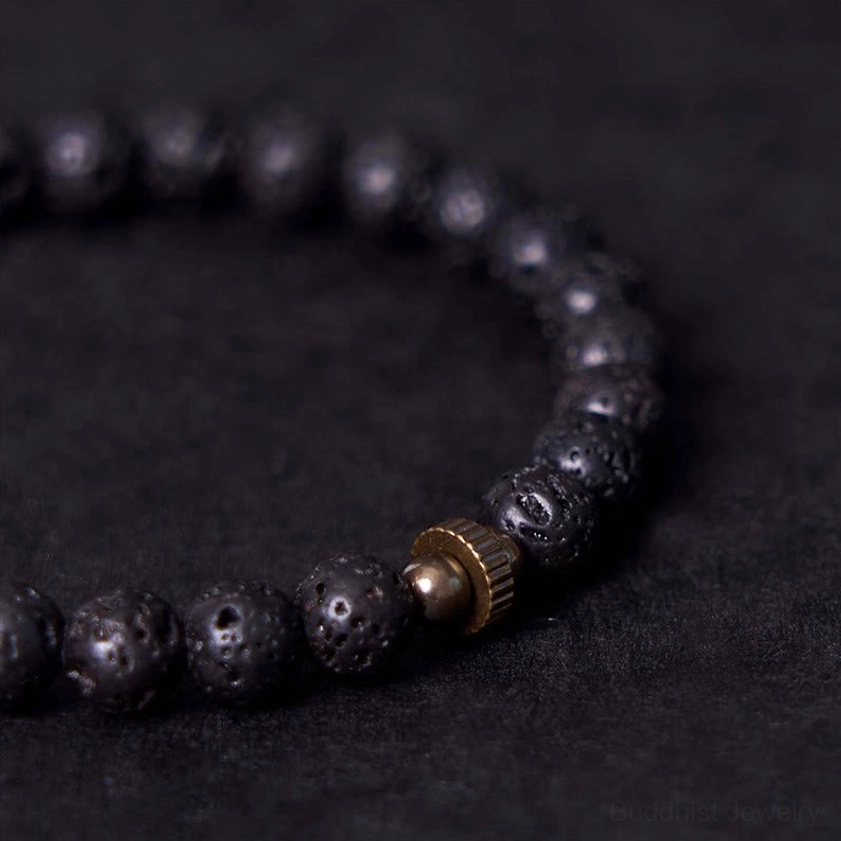 Macro close-up of lava rock bracelet beads and antique bronze barrel clasp, showing detailed porous volcanic stone surface texture