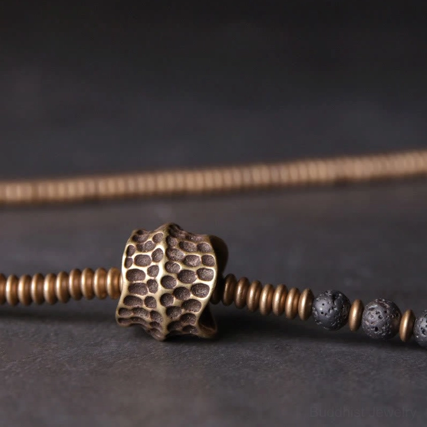 Macro close-up of lava rock beads and textured brass spacer components - detail shot