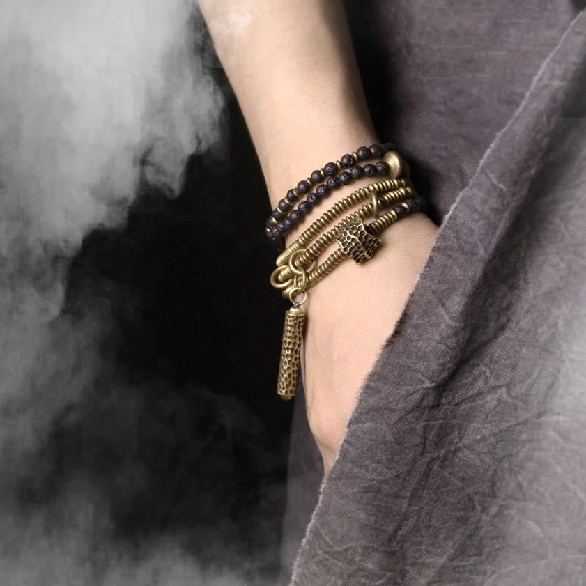Black lava rock and brass beaded bracelet worn on wrist - close-up side view with grounding energy styling