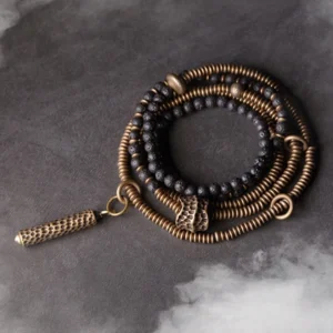 Vintage lava rock and brass multilayered healing bracelet set with tassel charm - top-down flat lay view