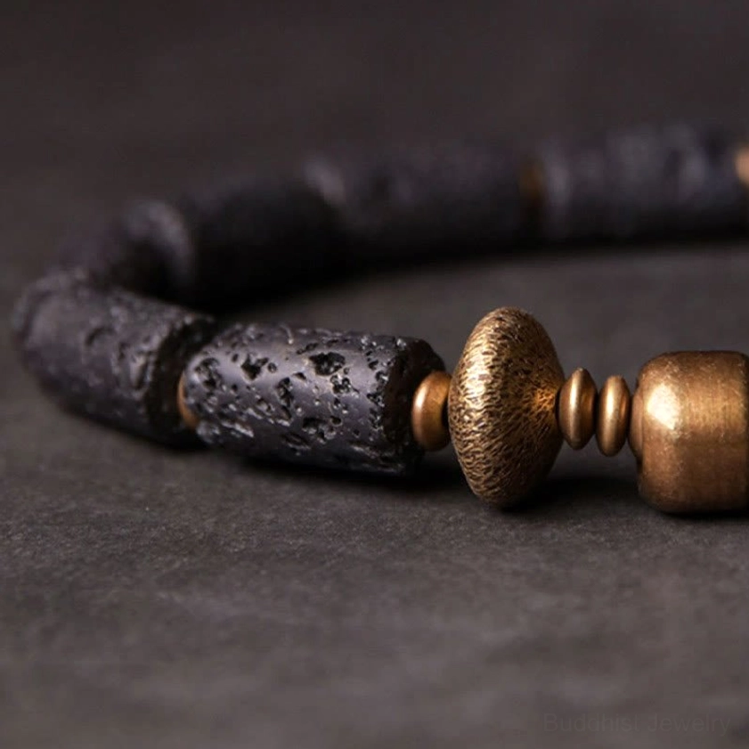 Detailed view of black lava cylinder beads and round copper beads showing natural porous texture