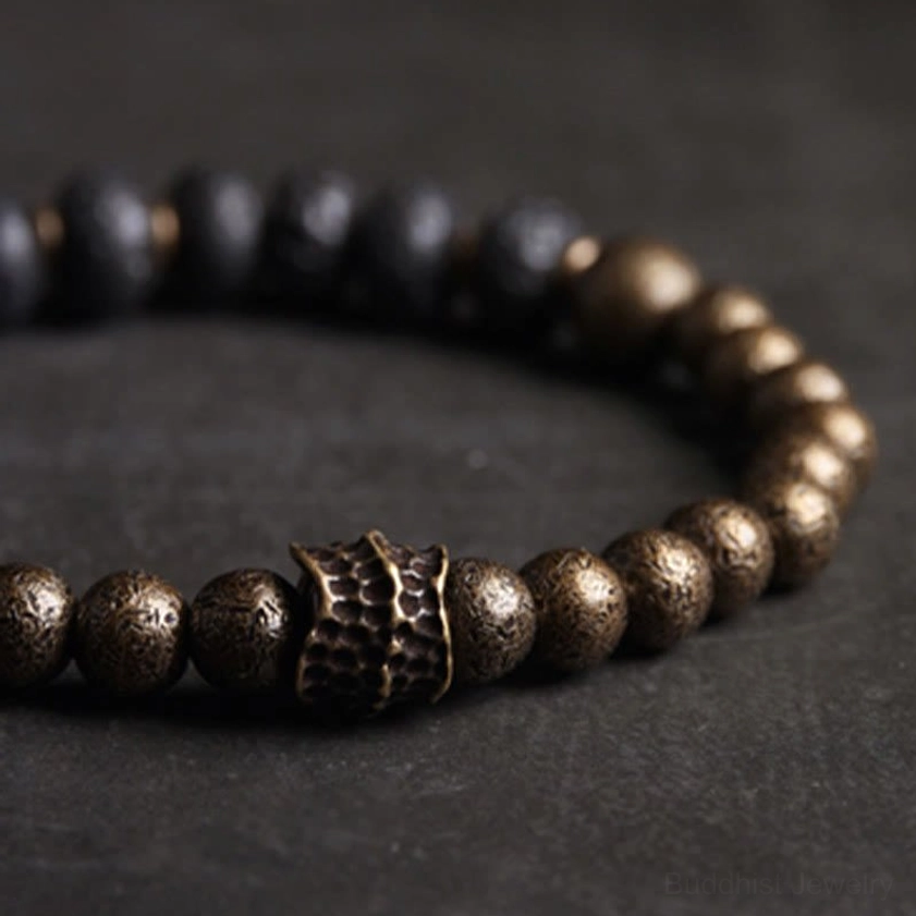 Close-up side view of lava rock copper bracelet showing textured black beads and polished brass spacers