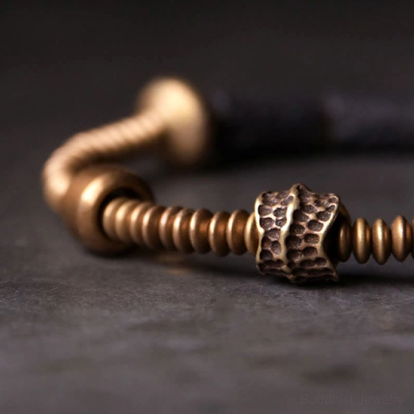 Close-up side view of black lava rock bracelet featuring hammered copper bead and spiral copper spacer rings
