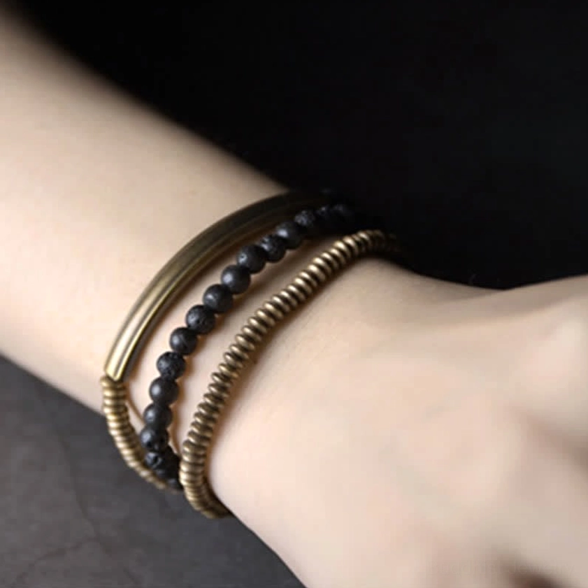 Three-strand vintage lava rock copper bracelet inner wrist detail showing antique brass metal accents and black volcanic beads