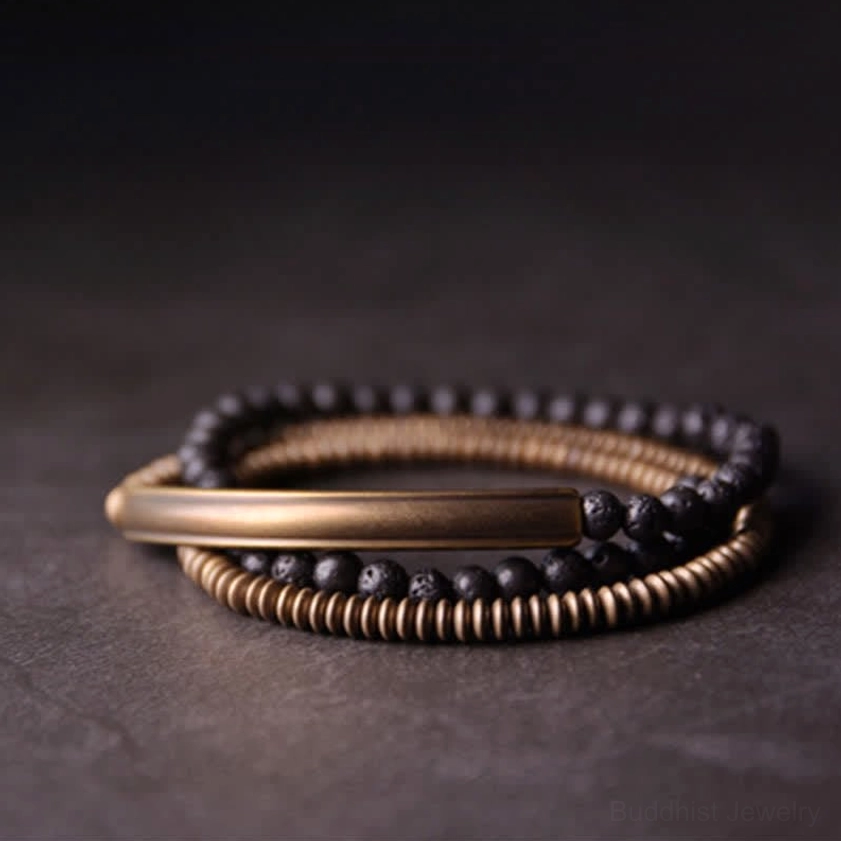 Lava rock copper bracelet set top-down flat lay showing antique brass metal tubes matte black volcanic stone beads on textured background