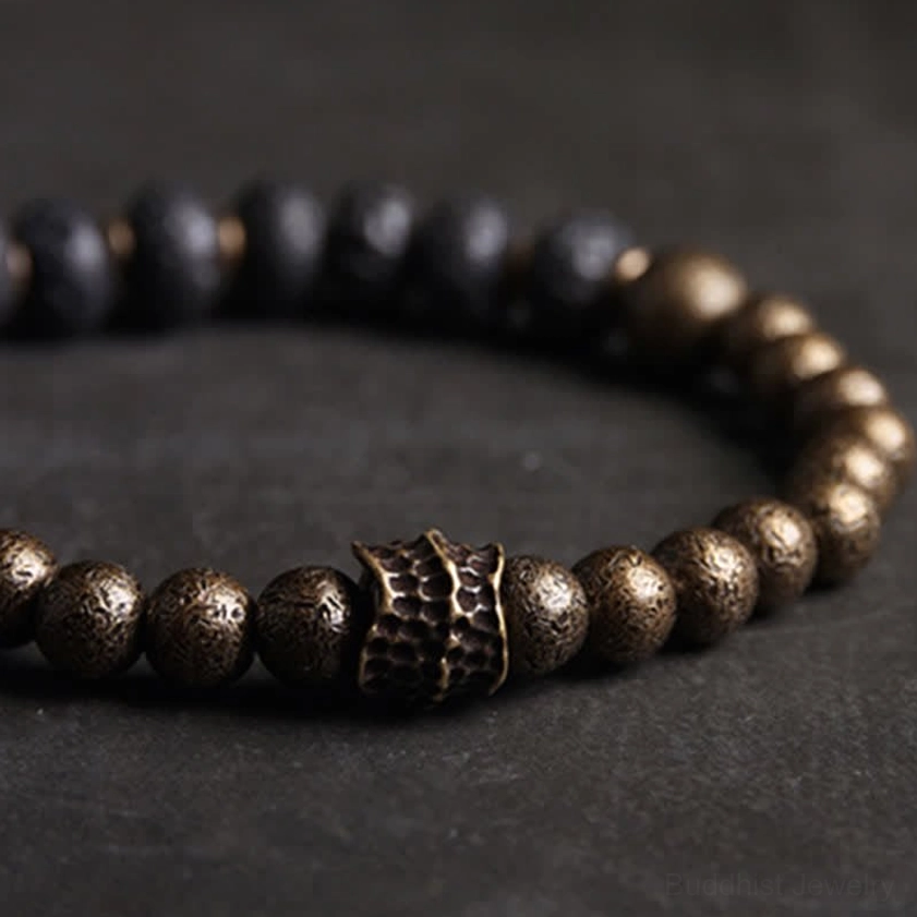 Ornate brass spacer beads and lava rock stones on elastic cord for balance bracelet construction