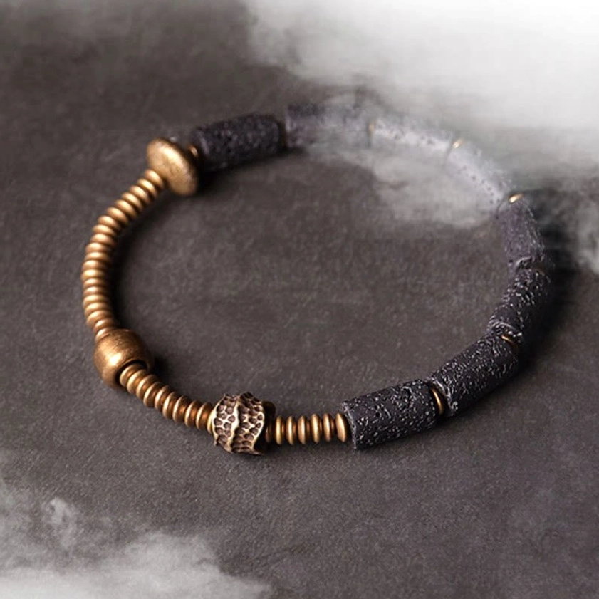 Black lava rock and copper beaded bracelet studio photography with atmospheric smoke effect