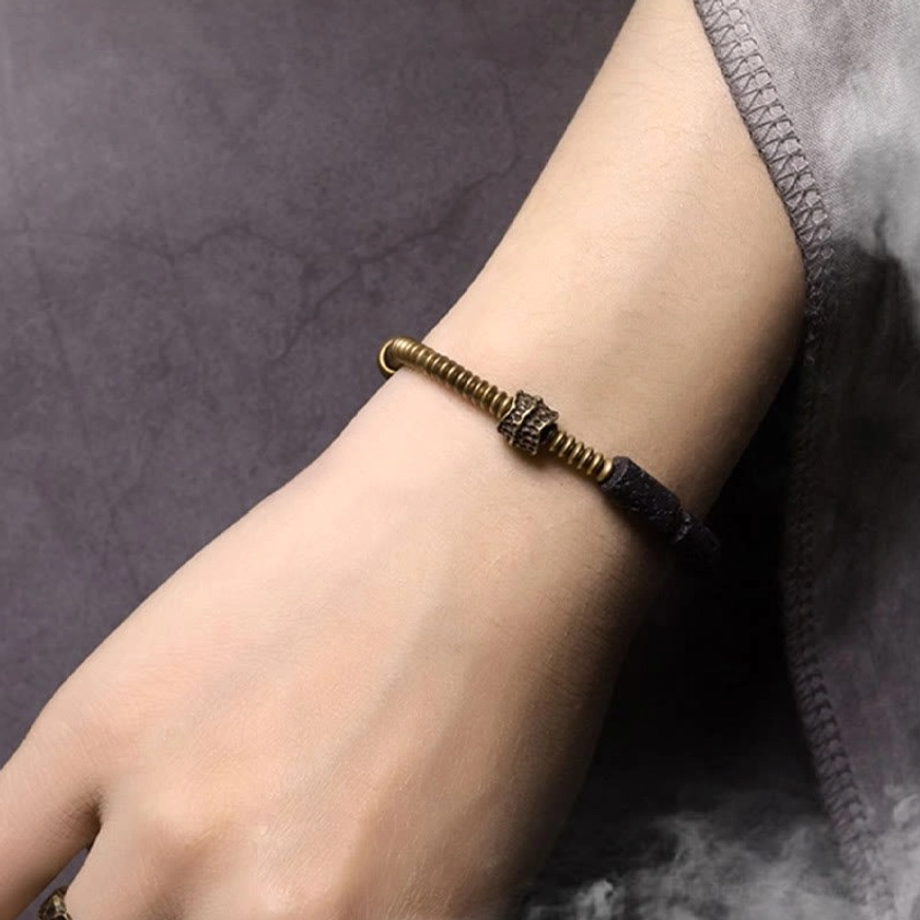Black lava rock and copper bracelet worn on human wrist showing minimalist unisex design