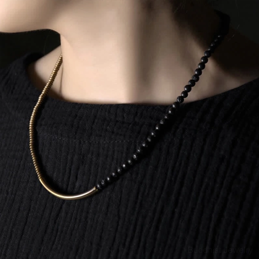 Antique copper and lava rock double-layered long chain necklace worn on neck over dark knit clothing showing vintage style