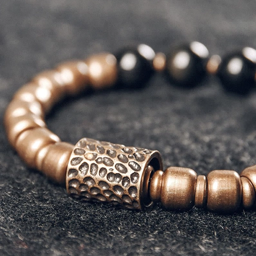 Close-up of individual lava rock beads with brass spacers, showing natural porous stone texture and handcrafted detail
