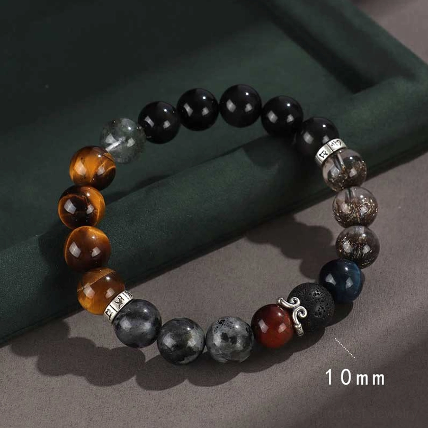 mixed healing stone buddhist bracelet with tiger eye lava rock and silver charm on dark green velvet