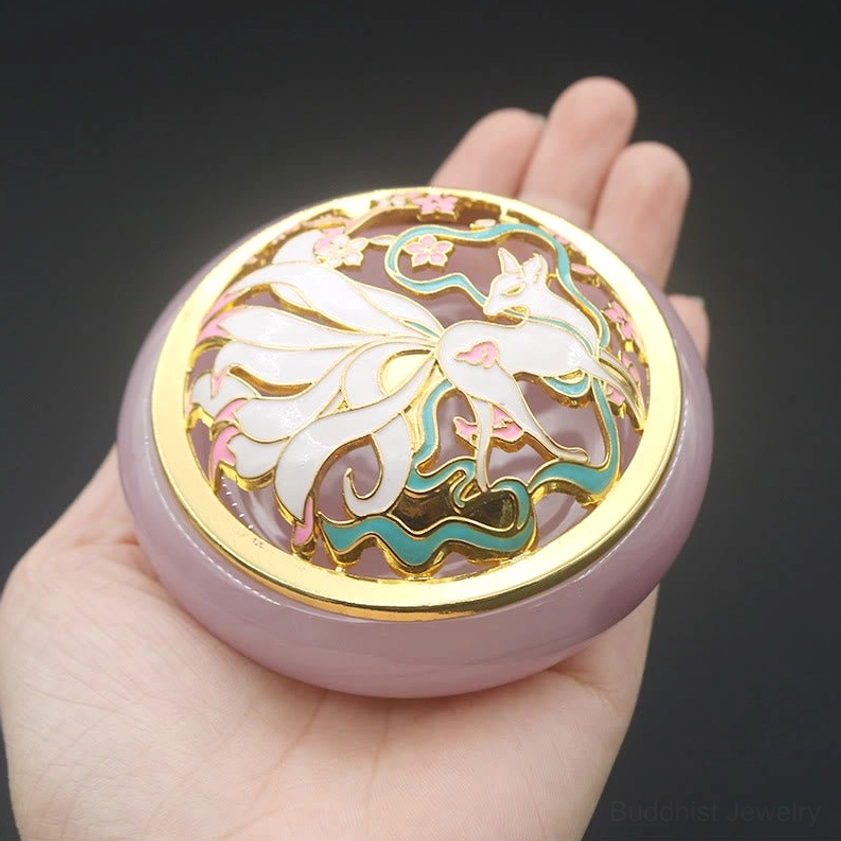 Handheld lavender nine-tailed fox incense burner first-person overhead view showing gold rim, nine-tailed fox and floral cloisonne artwork on decorative lid