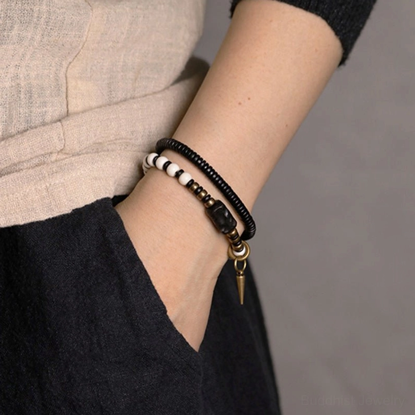 Stacked ebony wood bone bead bracelets on wrist showing layered beaded design