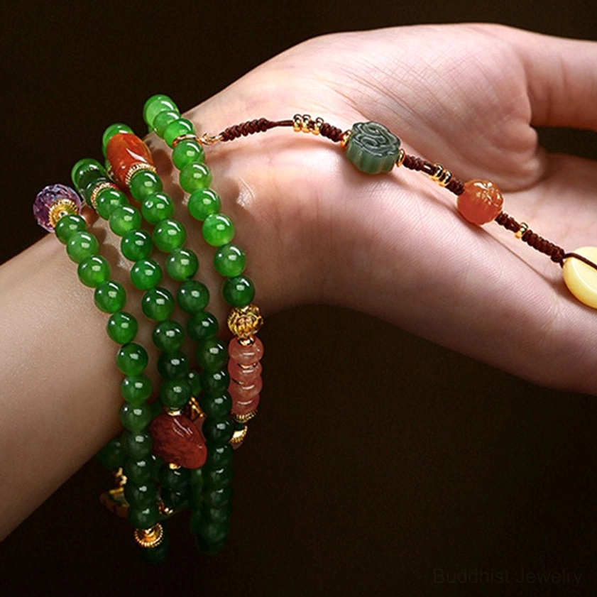 Multiple wrapped jade mala bracelets on palm showing layered wear and carved jade charms