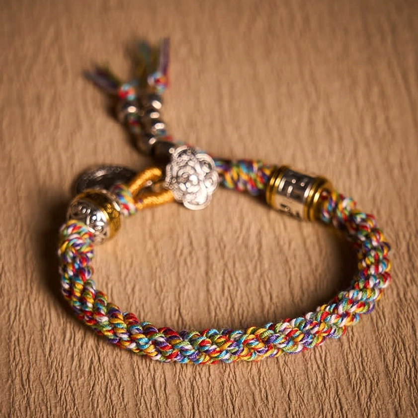 Light Colorful Woven Buddhist Bracelet Flatlay on Fabric Surface