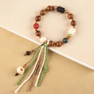 Lightning strike wood bodhi seed bracelet with cat paw charm and handwoven cotton tassel, top angled view showing mixed colored beads