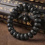 Lightning Strike Wood Buddhist protection bracelet with carved Om Mani Padme Hum mantra beads, flat lay on vintage calligraphy scroll background