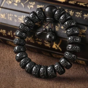 Lightning Strike Wood Buddhist protection bracelet with carved Om Mani Padme Hum mantra beads, flat lay on vintage calligraphy scroll background