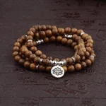 Lightning strike wood Buddhist mala bracelet with lotus silver pendant, handmade meditation beads on dark background