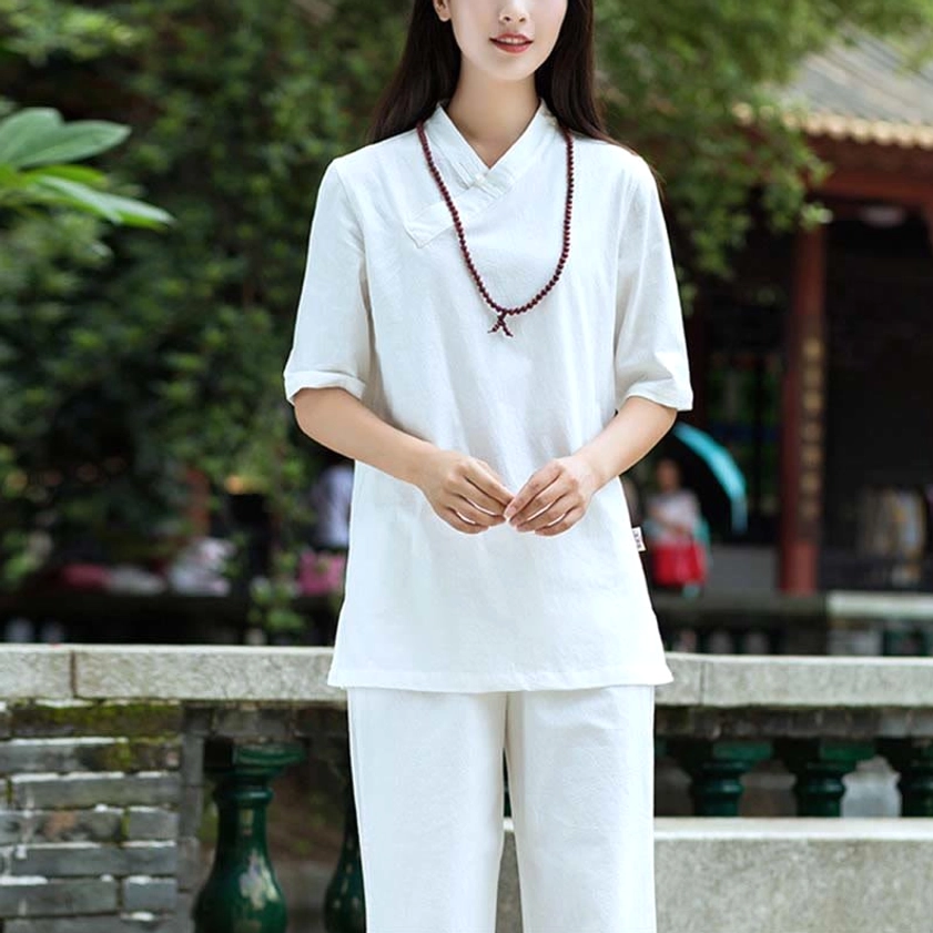 Pure white linen two-piece meditation and Tai Chi set with half-sleeve top and straight leg pants in traditional garden