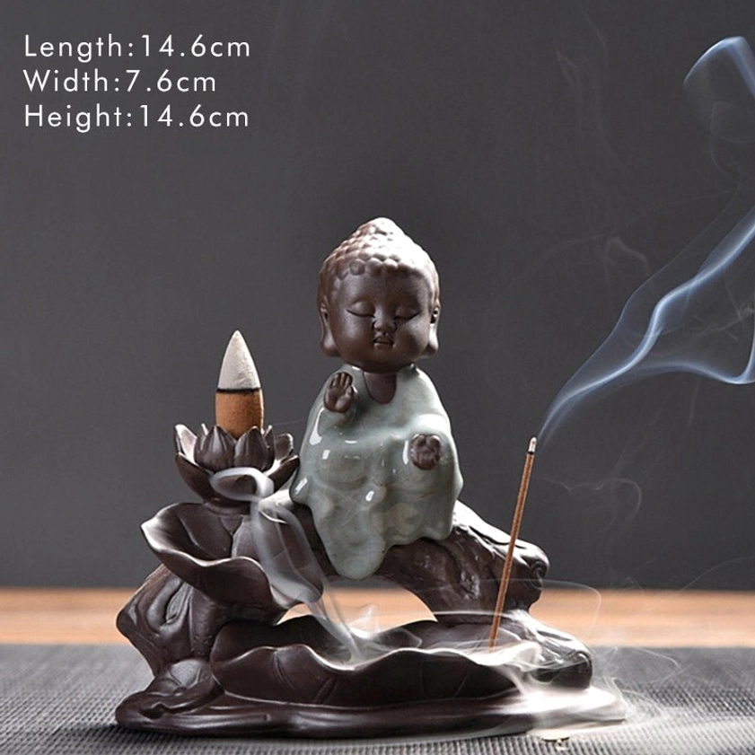 Little Tathagata ceramic backflow incense burner with size markings, front three-quarter view on dark grey display surface, dark brown ceramic with celadon finish, working backflow effect with lit incense
