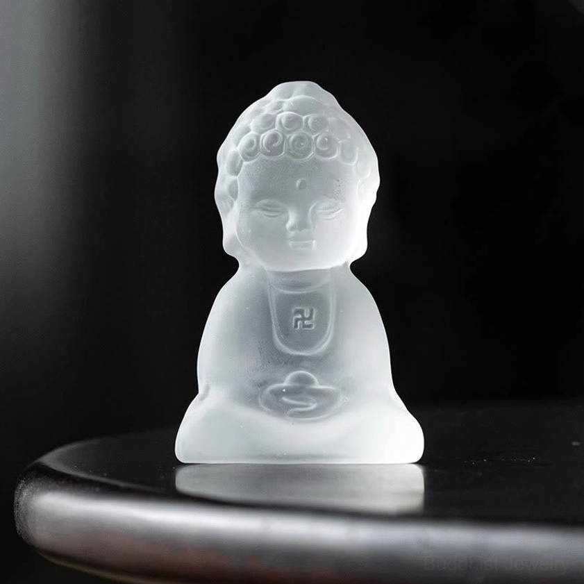 Hand-carved Liuli Buddha statue close-up showing serene facial features and meditation pose