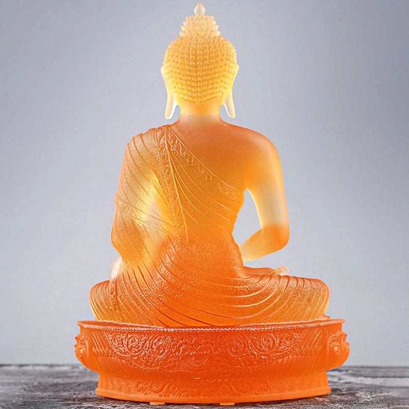 Liuli glass Buddha statue in home altar setting showing amber glass with gold plating for meditation and spiritual practice