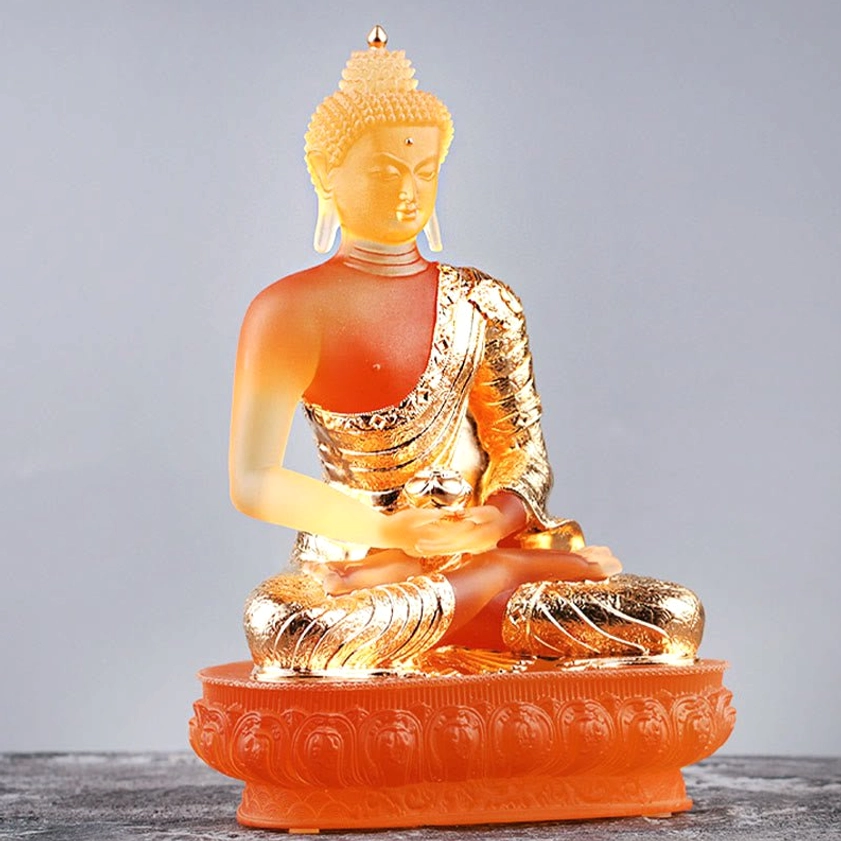 Liuli glass Buddha statue three-quarter angle view showing frosted amber glass with gold plated robe and lotus base