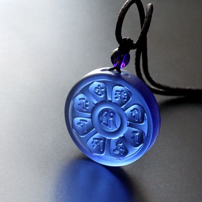 Deep blue crystal glass Buddhist necklace with carved mantra patterns and cotton cord detail