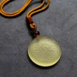 Eight-petal Liuli crystal wealth god mantra pendant necklace in light yellow translucent material with engraved Sanskrit mantras