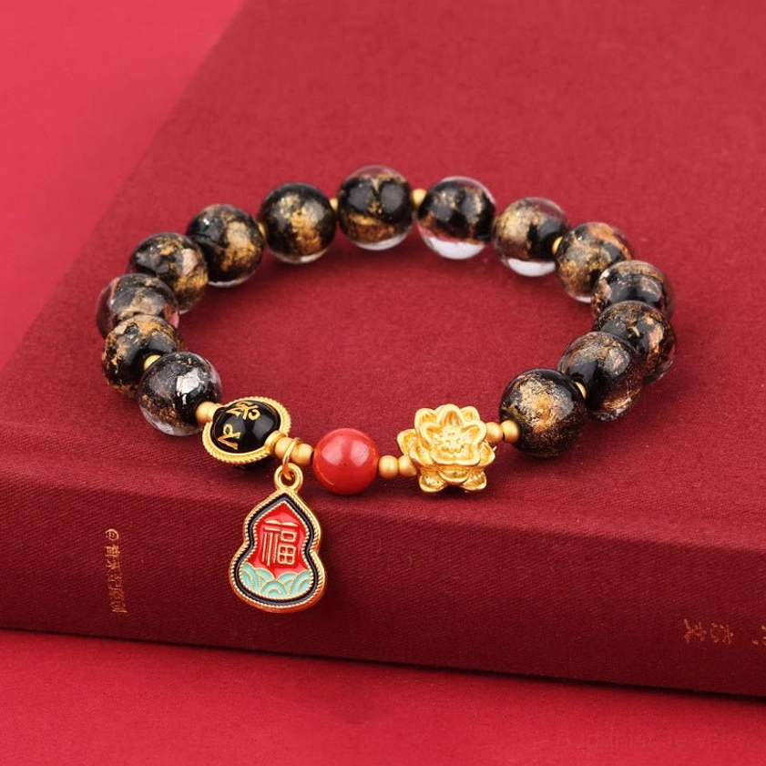 Sacred Buddhist mantra bracelet with incense ash glass beads and spiritual charms displayed on red hardcover book