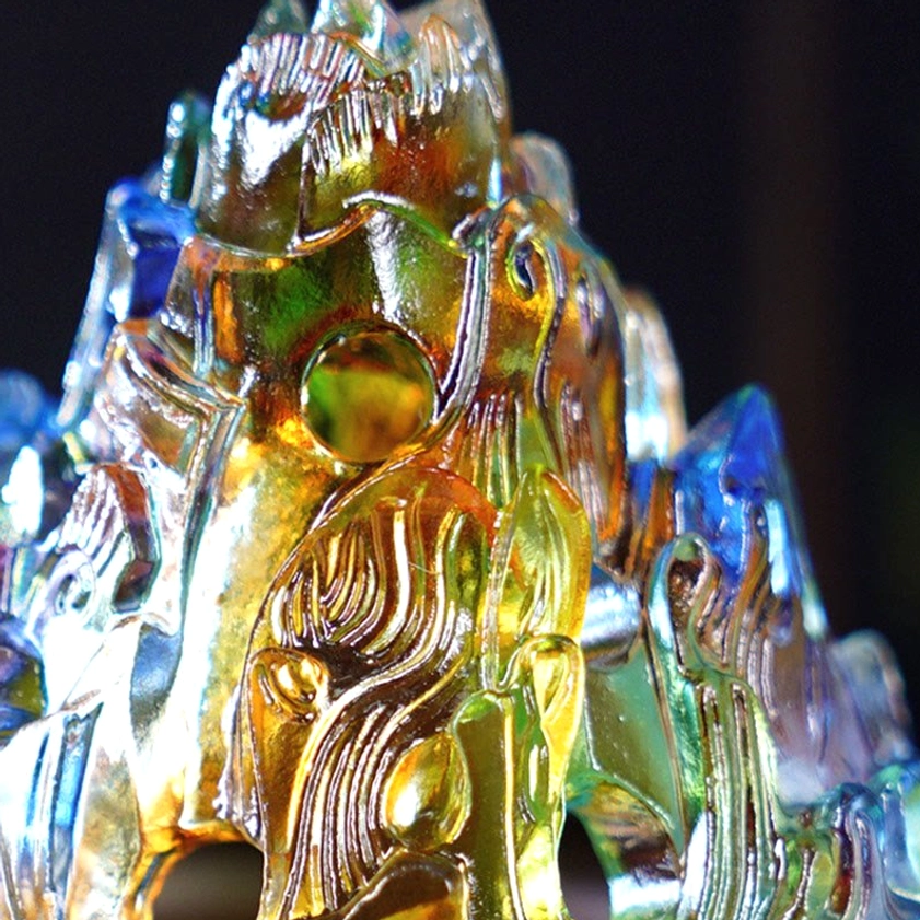 Extreme close-up of glossy Liuli glass mountain lid showing detailed carved textures and mixed color hues