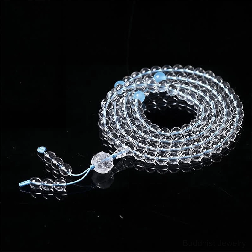 Blue string 108 bead Buddhist meditation mala with blue spacer beads and crystal tassel, flat lay view