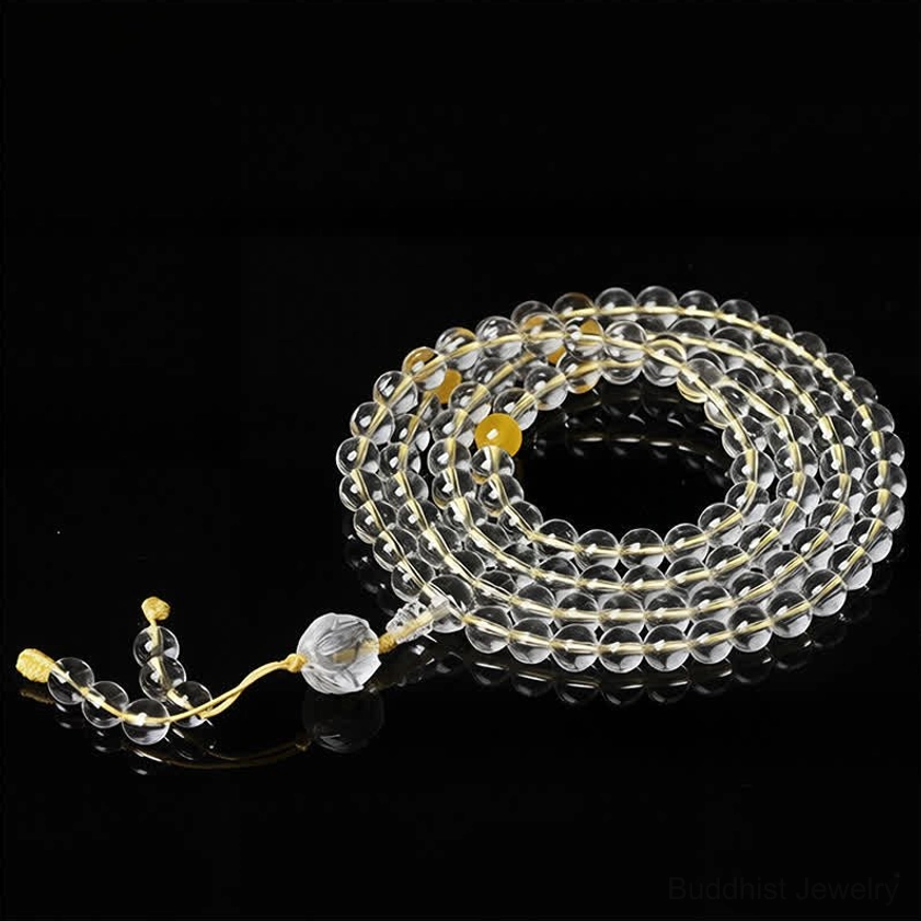 Yellow string 108 bead Buddhist prayer mala with liuli beads and crystal tassel, flat lay detail view