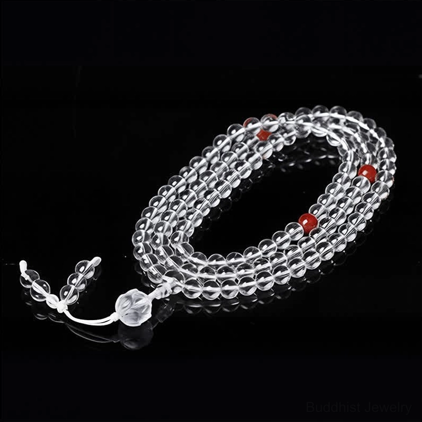 Buddhist meditation mala 108 beads with red spacer beads and crystal tassel, side flat lay studio view