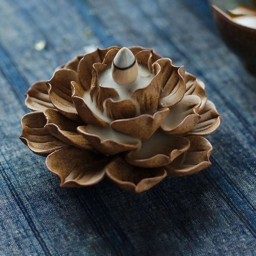 Three-quarter view of backflow lotus incense burner with brown petals and white inner incense well