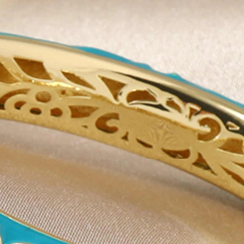 Close-up interior view of copper lotus bangle showing hollow carved gold floral pattern and enamel craftsmanship detail