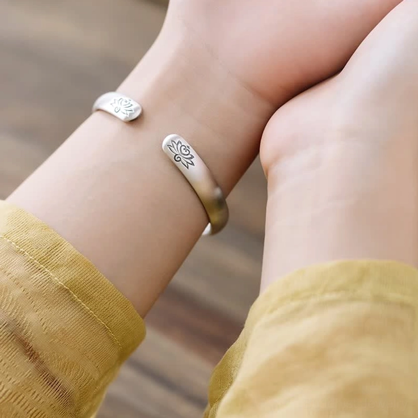 Woman wearing lotus bangle bracelet on wrist showing dual lotus engravings in daily casual outfit