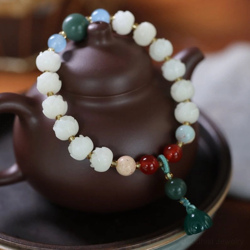 Bodhi seed lotus bracelet flat lay on traditional teapot with mixed gemstone beads and green lotus pendant