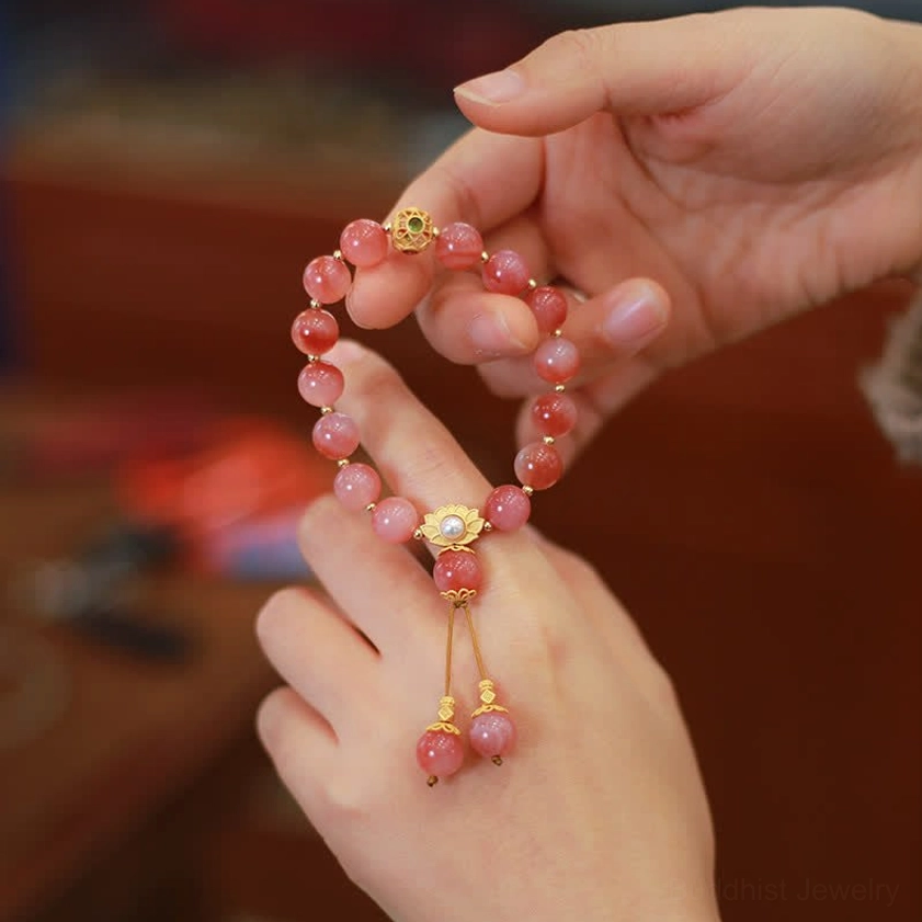 Pink agate lotus bracelet close-up held in hands showing beads and silver lotus clasp