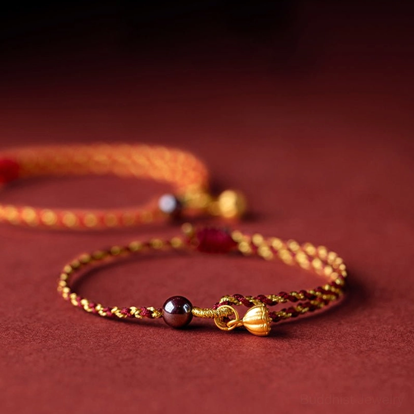 Two adjustable red gold braided Buddhist bracelets with lotus charms in different styles