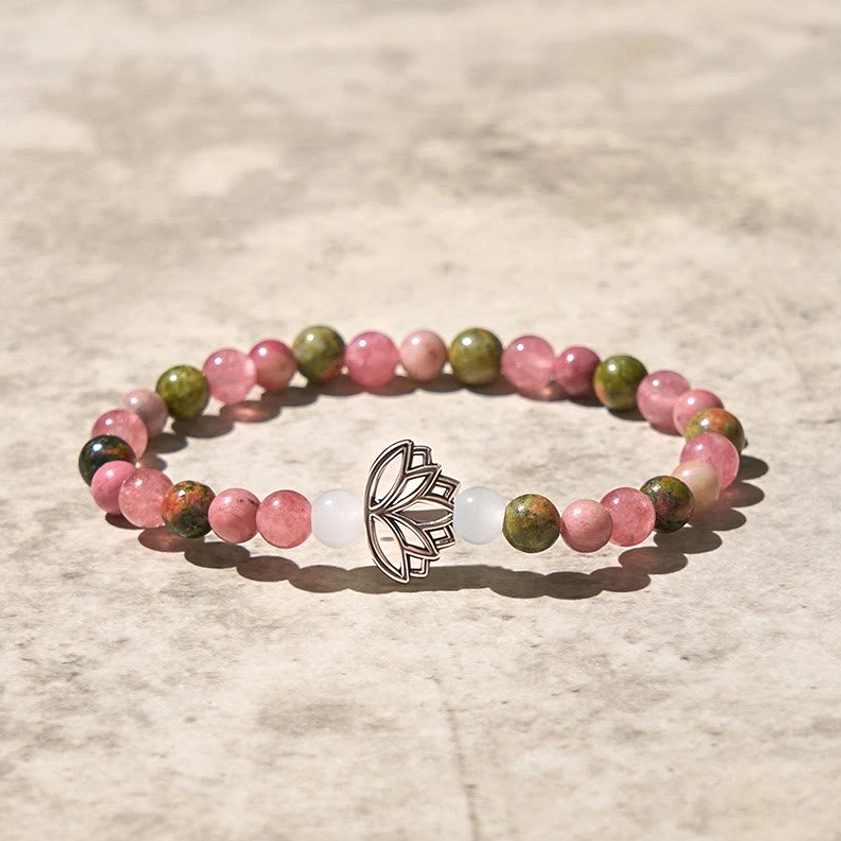Polished rhodonite and unakite beads with detailed silver lotus pendant minimalist flat lay