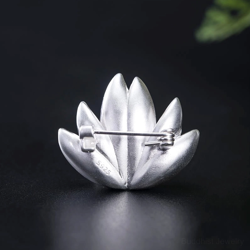 Reverse side of lotus brooch showing S925 hallmark and silver safety pin clasp mechanism on black backdrop