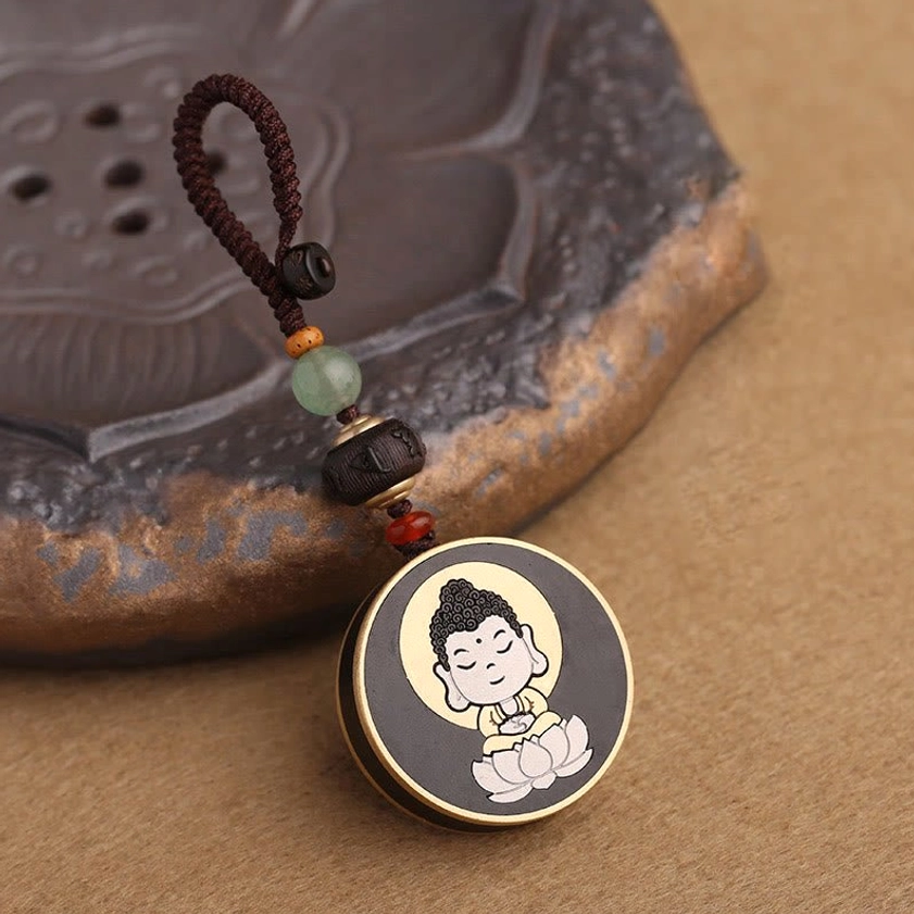 Lotus Buddha wooden keychain with jade and beaded accessories - top down view on metal coaster