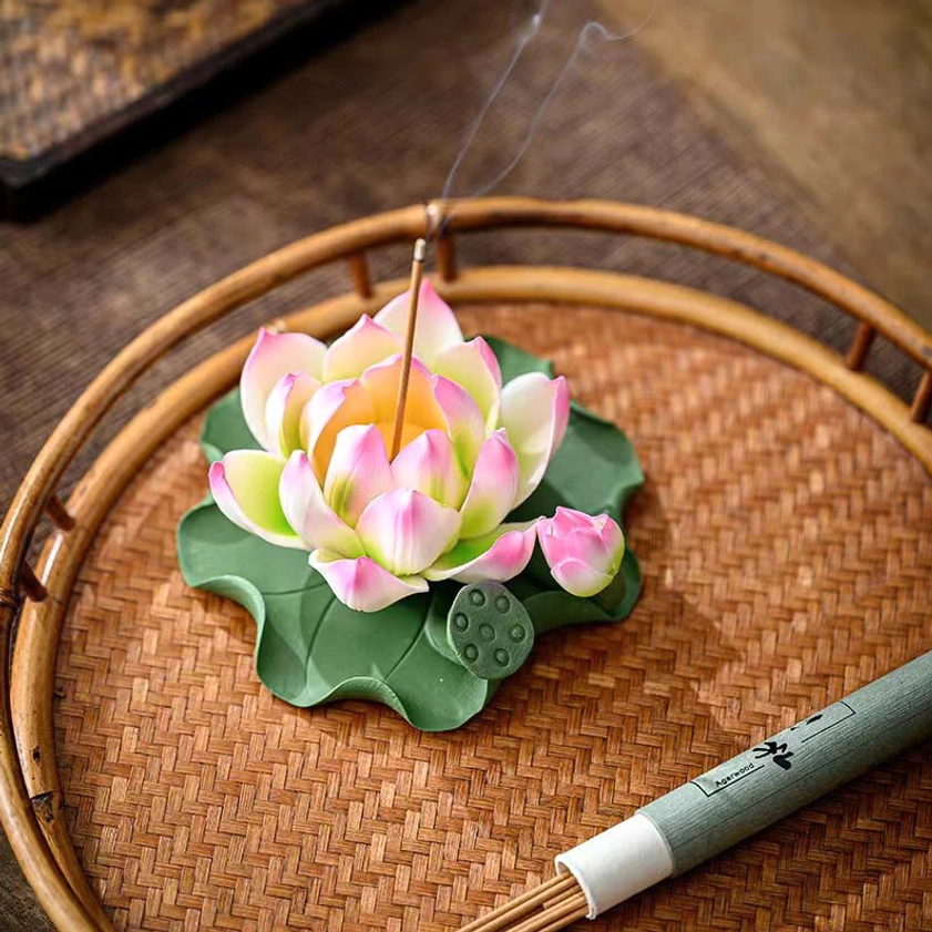 Handcrafted lotus ceramic incense burner on bamboo tray with smoking incense and packaging