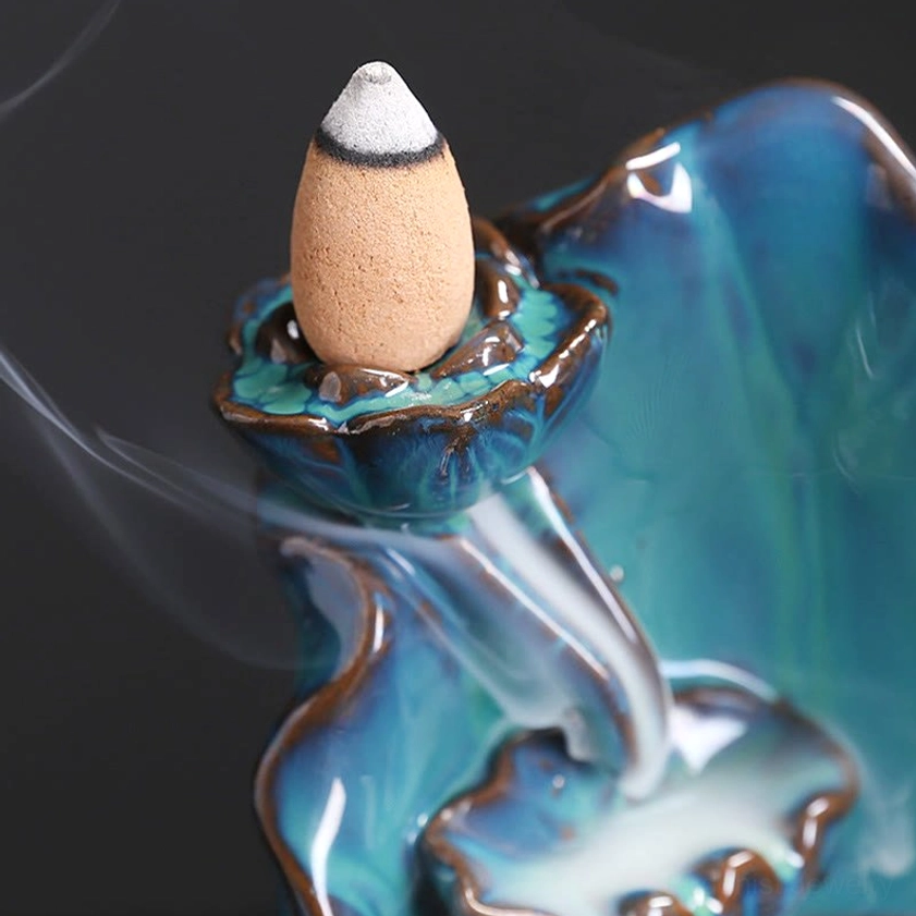 Close-up detailed view of blue lotus incense burner top showing mounted backflow incense cone with flowing aromatic smoke
